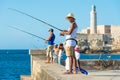 Cubans fishing in front of the famous El Morro castle in Havana