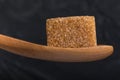 Cube of brown cane sugar in a wooden spoon of macro Royalty Free Stock Photo