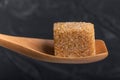 Cube of brown cane sugar in a wooden spoon of macro Royalty Free Stock Photo