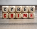 Cube, dice or blocks with cyber crime on wooden background