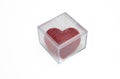Cube of glass with red ruby heart shape jewel isolated cutout on white background. Overhead view