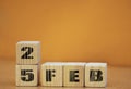 Cube shape calendar for february 25 on wooden surface with empty space for text, new year Wooden calendar with date, February cube Royalty Free Stock Photo