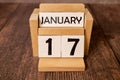 Cube shape calendar for January 17 on wooden surface with empty space for text,