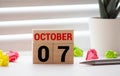 Cube shape calendar for October 07 on wooden surface with empty space for text