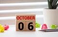 Cube shape calendar for October 06 on wooden surface with empty space for text