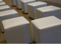 Cube shaped leather upholstered chairs line up in room