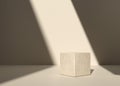 Cube shaped natural concrete or stone stand with beige wall and shadow background Royalty Free Stock Photo