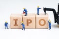 Cube wooden block with alphabets combine the word IPO with miniature people men help building with crane on white background using Royalty Free Stock Photo