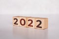 Cube wooden block with text year 2022, beginning and trend, calendar and time, determination target and planning.