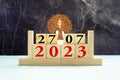 Cube wooden calendar showing date on 27 July. Wooden calendar with date on the table. blur objects on background