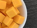 Cubed mild cheddar cheese in a white bowl