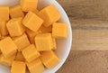 Cubed mild cheddar cheese in a white bowl