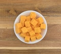 Cubed mild cheddar cheese in a white bowl