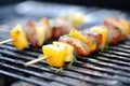 cubed pork and pineapple on skewers over grill Royalty Free Stock Photo