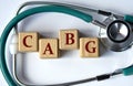 Cubes with the abbreviation CABG on the background of a stethoscope Royalty Free Stock Photo