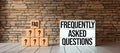 Cubes with the abbreviation FAQ and lightbox with message FREQUENTLY ASKED QUESTIONS - 3D rendered illustration