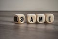 Cubes, blocks or dice with blame and shame on wooden background