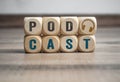 Cubes, blocks or dice with podcast and earphones on wooden background