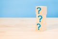 Cubes with blue question marks on wooden background, closeup. Space for text. Wooden cubes with question marks on wood table. FAQ