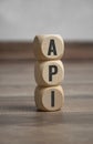 Cubes and dice with acronym API application programming interface on wooden background Royalty Free Stock Photo