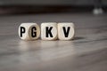 Cubes and dice with the acronyms PKV and GKV on wooden background