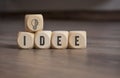 Cubes, dice and blocks with a brain and light bulb showing the word Idea and Idee on wooden background
