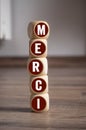 Cubes, dice or blocks with french word merci - thank you, thanks on wooden background Royalty Free Stock Photo