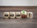 Cubes, dice or blocks with the german word for minimum wage - Mindestlohn on a wooden background Royalty Free Stock Photo