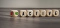 Cubes, dice or blocks with reactive and proactive on a wooden background