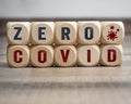 Cubes, dice or blocks with zero covid on wooden background