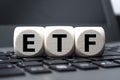 Cubes dice and calculator with etf on wooden background and laptop keyboard