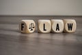 Cubes and dice with Flaw and Law on wooden background