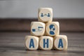 Cubes and dice with hygiene icons covid-19 corona virus and the german acronym for AHA - Abstand, Hygiene, Alltagsmaske on wooden