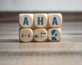 Cubes and dice with hygiene icons covid-19 corona virus and the german acronym for AHA - Abstand, Hygiene, Alltagsmaske on wooden