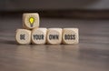 Cubes or dice with lightbulb and message Be your own boss on wooden background Royalty Free Stock Photo