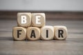 Cubes and dice with message Be fair on wooden background Royalty Free Stock Photo