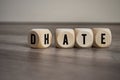 Cubes and dice with the opposite of hate and date on wooden background