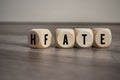 Cubes and dice with the opposite of hate and fate on wooden background