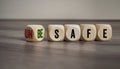 Cubes and dice with unsafe and be safe on wooden background