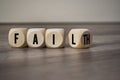 Cubes and dice on wooden background with fail and faith