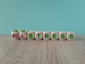 Cubes form words Stress free or ful. Beautiful blue background, wooden table, copy space. Royalty Free Stock Photo