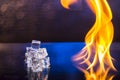 cubes of ice and fire on a water surface on an abstract background