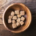 Cubes natural brown cane sugar in a wooden bowl on background. The concept of organic food. Selective focus. Royalty Free Stock Photo