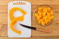 Cubes of pumpkin in plate, cutting board and knife Royalty Free Stock Photo