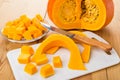 Cubes of pumpkin in plate, cutting board and knife Royalty Free Stock Photo