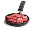 Cubes of raw beef meat on small frying pan isolated on white Royalty Free Stock Photo