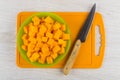 Cubes of raw pumpkin in bowl, knife on cutting board Royalty Free Stock Photo