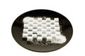 Cubes of refined sugar laid in a pattern on a black plate, crystal sugar scattered on top, isolated on white, front view Royalty Free Stock Photo
