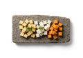 Cubes of various cheeses are arranged on a rectangular stone Royalty Free Stock Photo
