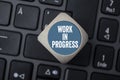 Cubes and dice with WIP work in progress on laptop keyboard Royalty Free Stock Photo